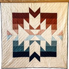 a quilted wall hanging with an abstract design