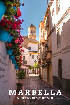 an alley way with flowers and buildings in the background that reads marbella andalusia spain