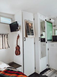 a bedroom with a guitar hanging on the wall