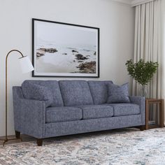 a living room with a blue couch and rug on the floor next to a window