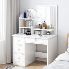 a bedroom with a bed, mirror and white dresser in it's corner next to a window