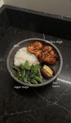 a plate with rice, broccoli and meat on it sitting on a counter