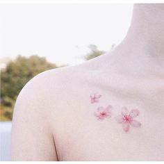 a close up of a person's chest with pink flowers on the left side