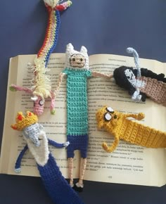 an open book with crocheted characters on it