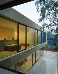 an office building with glass walls and large windows looking out onto the outside patio area