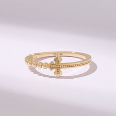 a gold ring with a cross on the front and beaded details around the band