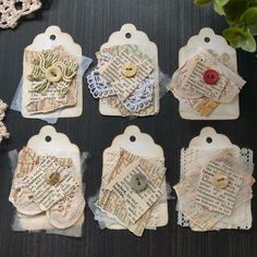 several pieces of altered paper with buttons and lace on them are sitting next to a potted plant