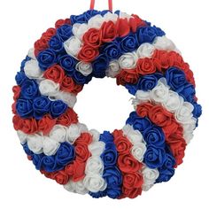 a wreath with red, white and blue flowers hanging on a string ornament