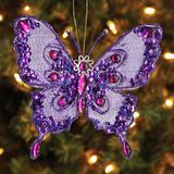 a purple butterfly ornament hanging from a christmas tree