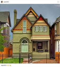 the house is painted green and brown with white trim on it's front door