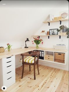 a desk with two drawers and a chair in the corner, next to shelves on the wall