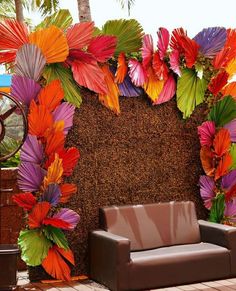 a couch sitting on top of a wooden floor next to a wall covered in colorful umbrellas