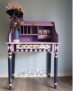 a purple desk with drawers and flowers on top