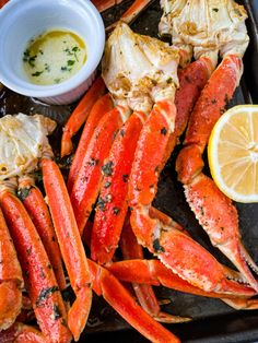 lobsters and crab legs on a tray with lemon wedges