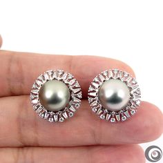 Beautiful designed S925 stud earrings with some sparkling CZ and organic natural color, Tahitian south sea cultured pearls from French Polynesia. Each of the Round genuine seawater pearl exhibits excellent high luster, thick nacre and radiant with minor natural spot/birthmarks. Style: Stud. Metal Purity: 925 Sterling Silver. Earring Width (approx.): 1.9cm Pearl Type: Genuine Tahitian seawater cultured pearl. Pearl Origin: French Polynesia Peal Shape: Round Pearl Main Color: Silver (one with hint Tahitian Pearl Earrings In White Gold For Anniversary, Fine Jewelry Silver Pearl Earrings, Silver Pearl Earrings With Gemstone Fine Jewelry, Silver Pearl Earrings With Gemstone For Anniversary, Fine Jewelry Silver Pearl Earrings With Gemstones, High Luster Silver Round Pearl Earrings, Tahitian Pearl Round Anniversary Earrings, Silver Pearl Earrings With Gemstone, Silver Tahitian Pearl Earrings For Wedding