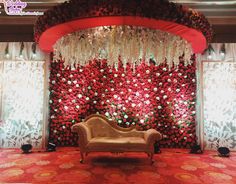 a couch sitting in front of a red and white wall with flowers on it's side