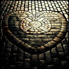 a heart made out of cobblestones on the ground