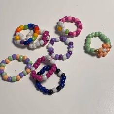 several bracelets are arranged on a white surface, including one with multicolored beads