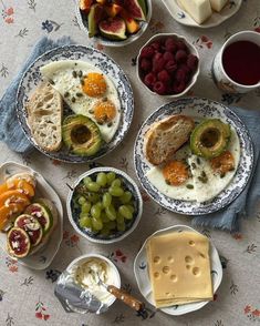 a table topped with plates of food and bowls of fruit