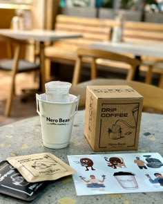 a coffee cup sitting on top of a table next to some stickers and papers