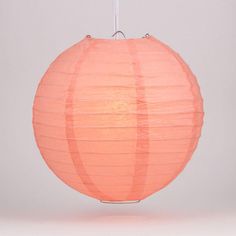 an orange paper lantern hanging from a white ceiling