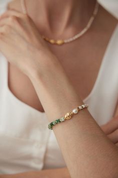 This bracelet combines the serene beauty of Qinghai jade with the lustrous appeal of pearls and the subtle elegance of mother of pearl, all complemented by golden accents. Perfect for adding a touch of sophistication to any outfit, this piece is ideal for those who cherish a blend of traditional materials in a modern design. Embrace this timeless accessory, designed to offer versatility and luxury for any occasion. Material: Qinghai Jade, Natural Pearl, Mother of Pearl, 925 Silver Color: Vintage Vintage Gold Bracelet, Gold Arm Band, Gold Armband, Subtle Elegance, Jade Bracelet, Color Vintage, Natural Pearl, Timeless Accessories, Pearl Size