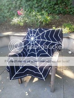 a black and white spider web blanket on a wooden bench