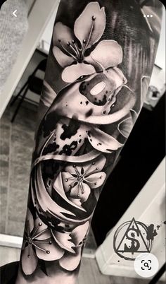 a black and white photo of flowers on the arm, done by tattoo artist steve