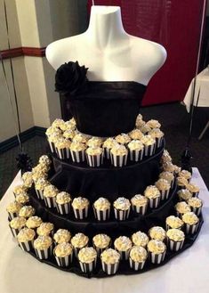 a three tiered cake with cupcakes on it