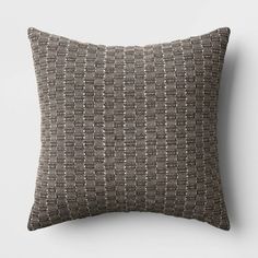 a brown and black pillow on a white wall