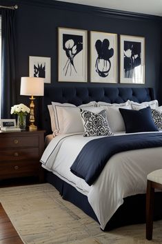 a bedroom with blue walls and white bedding, two framed pictures on the wall