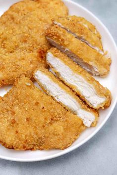 fried chicken cut in half on a white plate