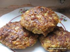 three crab cakes on a white plate with red trim