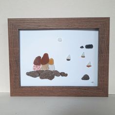 there is a shadow frame with rocks and mushrooms in the middle, on top of a white surface