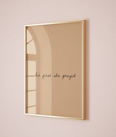 a mirror hanging on the wall above a shelf with a vase in front of it