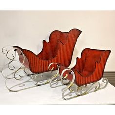 two red sleighs sitting on top of a white table