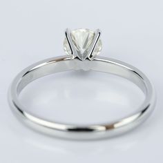 a white gold ring with a single diamond