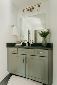 a bathroom with a sink, mirror and rug on the floor in front of it