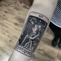 a tattoo on the arm of a woman with an image of a tarot card