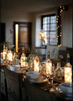 a long table is set with candles and plates for dinner guests to sit down at