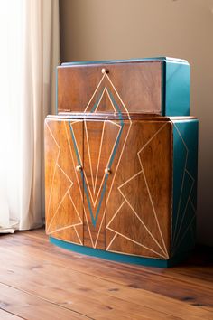 two pieces of art deco furniture sitting on top of a hard wood floor next to a window