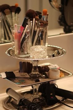 three tiered tray with makeup and hair dryers on it