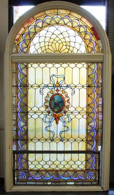 an ornate stained glass window in the corner of a room