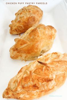 three croissants sitting on top of a white tray