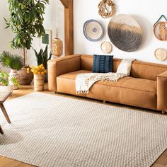 a living room filled with lots of furniture and decor on the wall above it is a brown leather couch