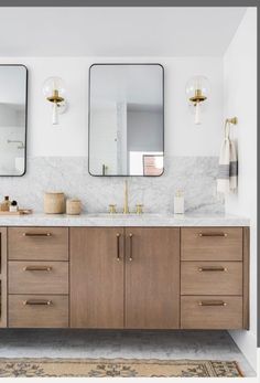 a bathroom vanity with two mirrors above it