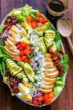 a large salad with avocado, tomatoes, lettuce and other vegetables