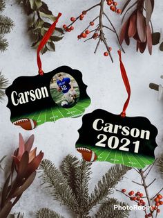 two personalized football ornament hanging from a christmas tree