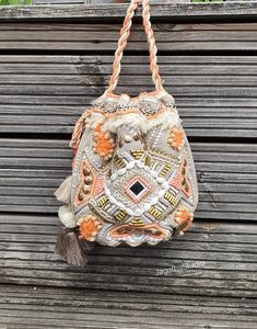 HANDMADE The perfect accessory, for a Boho Chic look! Inspired by a boho spirit, this chic bucket bag combines earth colors and textures with a touch of spark and natural beautiful tones. Crafted from cotton with beautiful details, beads work, pompons, embellish tassels, a fringe along the front and beautiful details, this bag won't be un notice. With beautiful double colour cotton strap, that can be worn as a should or cross body bag, by creating a knot with the strap. Ideal for a casual look o Bohemian Beaded Bags For Vacation, Bohemian Beaded Shoulder Bag For Vacation, Bohemian Embellished Bag For Vacation, Bohemian Embellished Bags For Vacation, Bohemian Beaded Shoulder Bag For The Beach, Bohemian Beaded Shoulder Bag For Beach, Handmade Festival Pouch Bags, Bohemian Pouch Bag For Festival, Woven Pouch Bag For Festivals