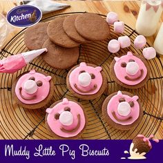 some cookies are on a wire rack with pink frosting and teddy bears in the middle